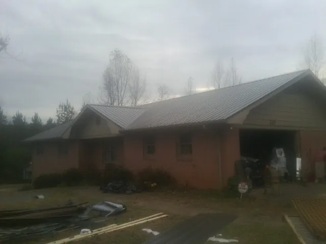 Gray metal roof on a stucco house with an attached garage in Temple